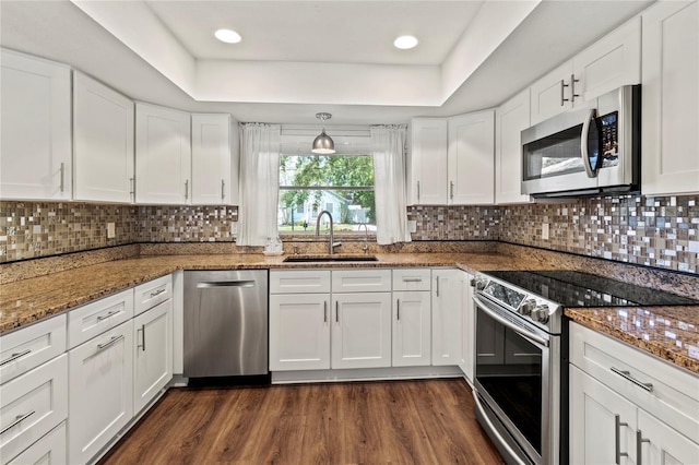 2515 Huntington Ave, Sarasota, FL 34232 - kitchen with stainless steel appliances, a sink, white cabinets, dark wood-style flooring, and a raised ceiling