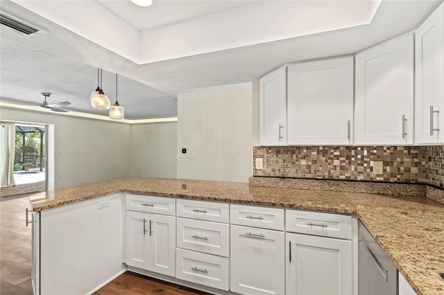 2515 Huntington Ave, Sarasota, FL 34232 - kitchen with a peninsula, white cabinets, decorative backsplash, light stone counters, and a ceiling fan
