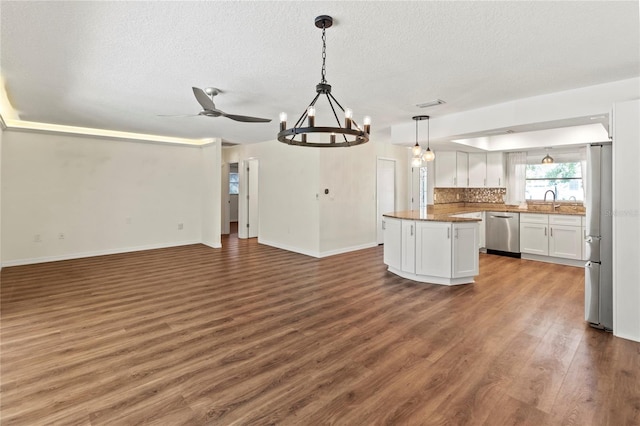 2515 Huntington Ave, Sarasota, FL 34232 - kitchen featuring stainless steel dishwasher, open floor plan, white cabinets, wood finished floors, and a kitchen island