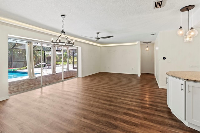 2515 Huntington Ave, Sarasota, FL 34232 - unfurnished dining area with a textured ceiling, baseboards, dark wood finished floors, a ceiling fan, and a chandelier