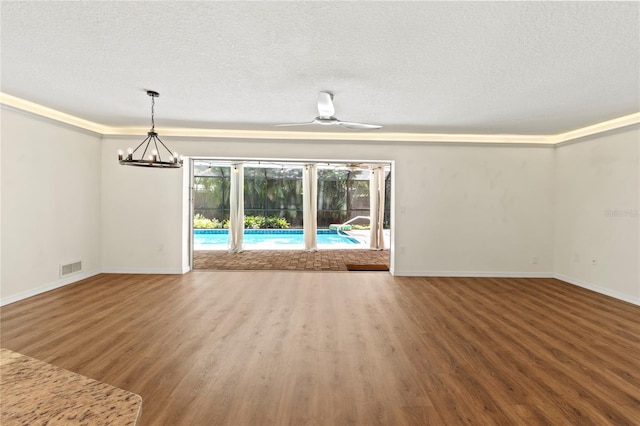 2515 Huntington Ave, Sarasota, FL 34232 - unfurnished living room featuring wood finished floors, a textured ceiling, baseboards, a chandelier, and ceiling fan