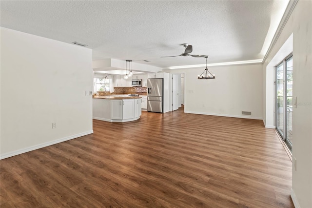 2515 Huntington Ave, Sarasota, FL 34232 - unfurnished living room featuring a textured ceiling, dark wood-style floors, a chandelier, baseboards, and ceiling fan
