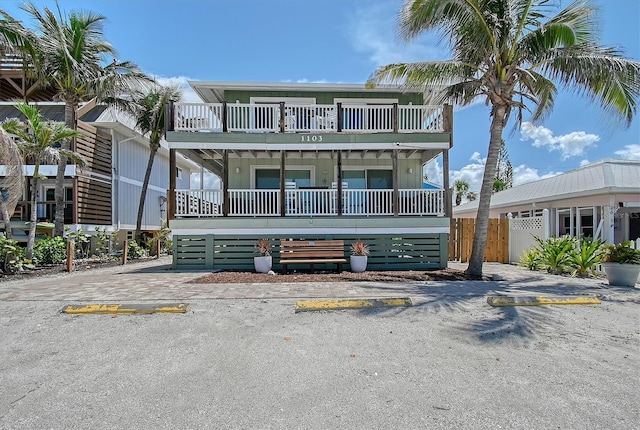 1103 Shore View Dr, Englewood, FL 34223 - view of front of home with uncovered parking, a balcony, board and batten siding, and a porch