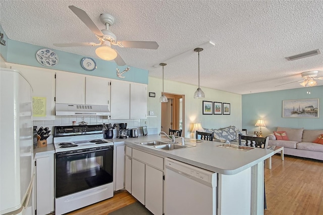 1103 Shore View Dr, Englewood, FL 34223 - kitchen featuring white appliances, under cabinet range hood, a sink, a ceiling fan, and a peninsula
