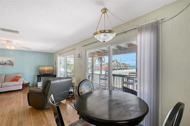 1103 Shore View Dr, Englewood, FL 34223 - dining space featuring a textured ceiling, light wood-style flooring, and ceiling fan