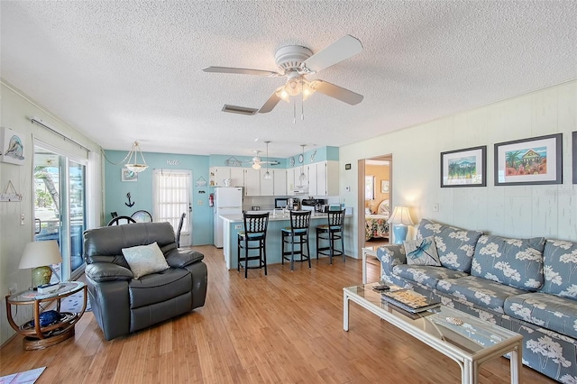 1103 Shore View Dr, Englewood, FL 34223 - living room featuring a textured ceiling, light wood finished floors, and a ceiling fan
