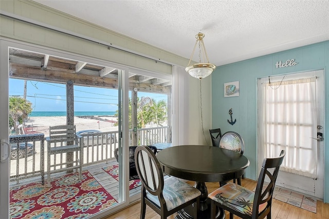 1103 Shore View Dr, Englewood, FL 34223 - dining room featuring a water view, light wood-type flooring, and a textured ceiling
