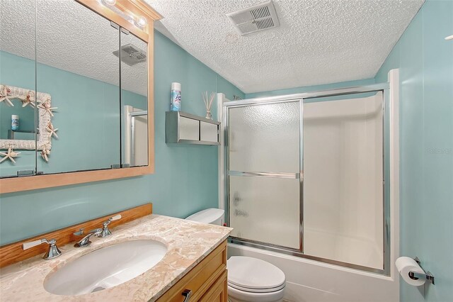 1103 Shore View Dr, Englewood, FL 34223 - full bath featuring toilet, a textured ceiling, vanity, and combined bath / shower with glass door