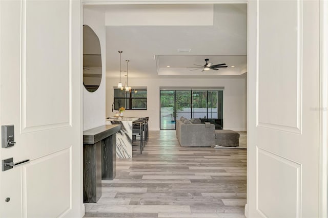 2546 Malibu Ln, North Port, FL 34286 - hall featuring a raised ceiling, light wood-style floors, a chandelier, and recessed lighting