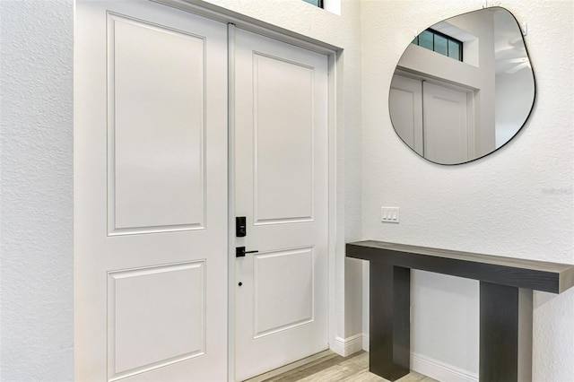 2546 Malibu Ln, North Port, FL 34286 - foyer entrance with light wood finished floors, a textured wall, and baseboards