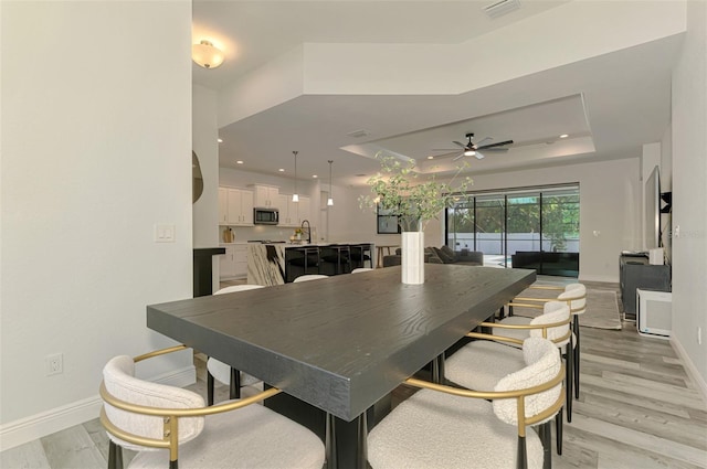 2546 Malibu Ln, North Port, FL 34286 - dining area featuring baseboards, a raised ceiling, ceiling fan, light wood finished floors, and recessed lighting