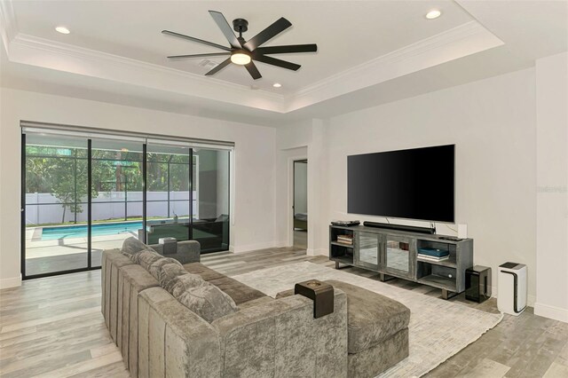 2546 Malibu Ln, North Port, FL 34286 - living area with a raised ceiling, ceiling fan, light wood finished floors, baseboards, and ornamental molding