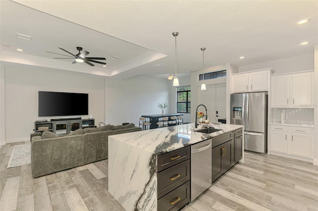 2546 Malibu Ln, North Port, FL 34286 - kitchen with a sink, stainless steel appliances, white cabinetry, light wood finished floors, and a raised ceiling
