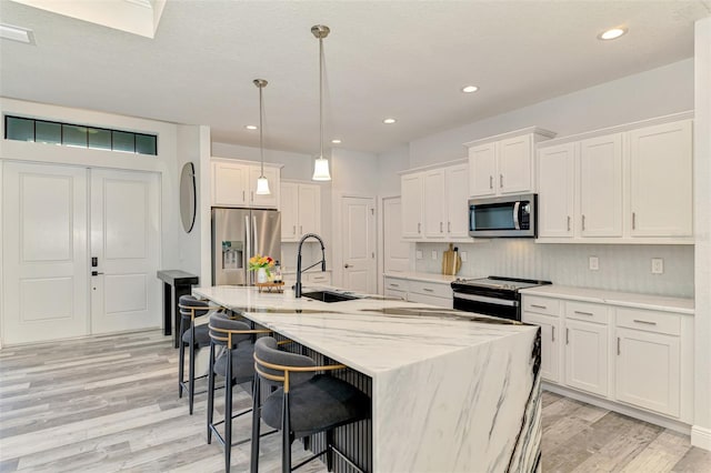 2546 Malibu Ln, North Port, FL 34286 - kitchen with appliances with stainless steel finishes, a sink, light wood finished floors, white cabinets, and recessed lighting