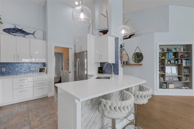 4120 51st Dr W, Bradenton, FL 34210 - kitchen featuring stainless steel fridge with ice dispenser, modern cabinets, white cabinets, a breakfast bar area, and decorative backsplash