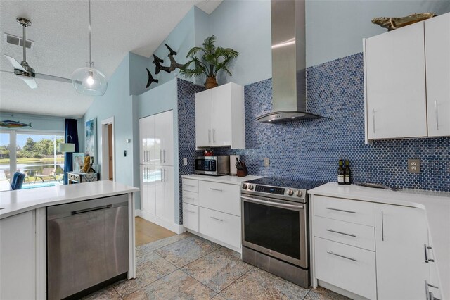 4120 51st Dr W, Bradenton, FL 34210 - kitchen featuring stainless steel appliances, wall chimney exhaust hood, a textured ceiling, vaulted ceiling, and decorative backsplash