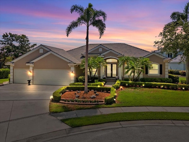 7513 Coventry Ct, Lakewood Ranch, FL 34202 - ranch-style house with french doors, an attached garage, concrete driveway, a front yard, and stucco siding