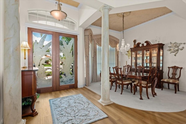 7513 Coventry Ct, Lakewood Ranch, FL 34202 - foyer entrance with french doors, ornate columns, a chandelier, wood finished floors, and ornamental molding