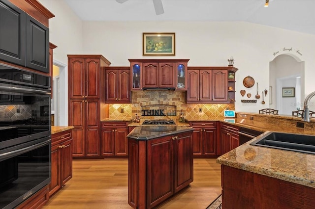 7513 Coventry Ct, Lakewood Ranch, FL 34202 - kitchen featuring double oven, dark brown cabinets, a sink, light wood-type flooring, and tasteful backsplash
