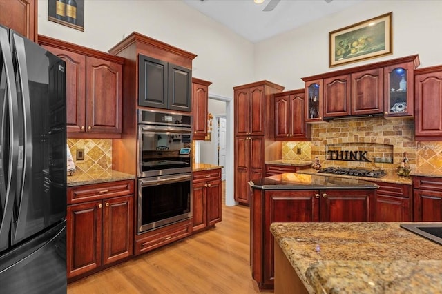 7513 Coventry Ct, Lakewood Ranch, FL 34202 - kitchen with appliances with stainless steel finishes, light wood-style floors, glass insert cabinets, and light stone counters