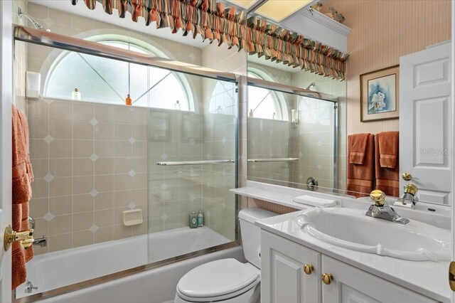 7513 Coventry Ct, Lakewood Ranch, FL 34202 - bathroom featuring vanity, toilet, bath / shower combo with glass door, and wallpapered walls