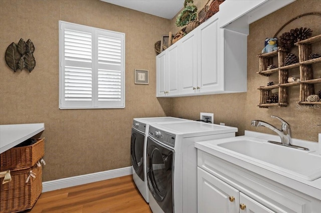 7513 Coventry Ct, Lakewood Ranch, FL 34202 - laundry room featuring washing machine and clothes dryer, cabinet space, light wood-type flooring, and baseboards
