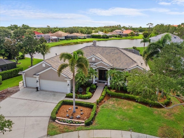 7513 Coventry Ct, Lakewood Ranch, FL 34202 - view of front of property featuring concrete driveway, a water view, a garage, a front lawn, and a tile roof
