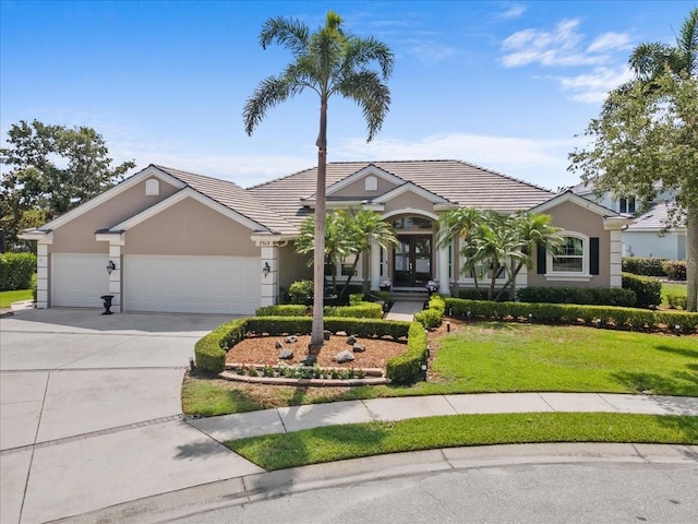 7513 Coventry Ct, Lakewood Ranch, FL 34202 - view of front of house featuring concrete driveway, a front lawn, an attached garage, and stucco siding