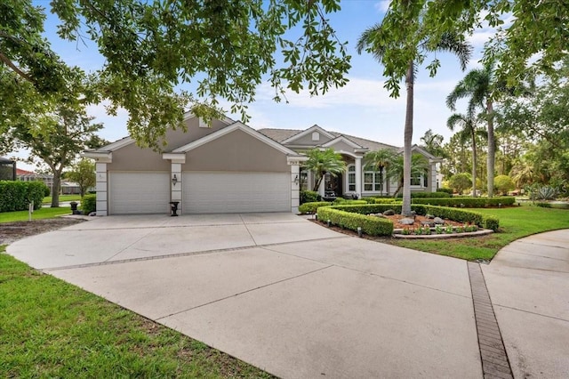 7513 Coventry Ct, Lakewood Ranch, FL 34202 - view of front facade featuring an attached garage, concrete driveway, stucco siding, and a front lawn