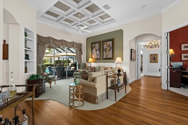 7513 Coventry Ct, Lakewood Ranch, FL 34202 - living room featuring arched walkways, ornamental molding, coffered ceiling, wood finished floors, and beamed ceiling