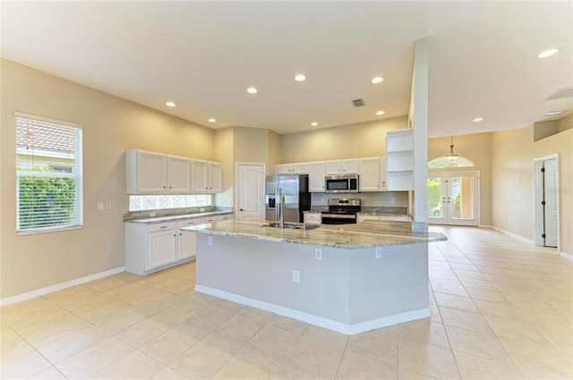 8772 Stone Harbour Loop, Bradenton, FL 34212 - kitchen with stainless steel appliances, light tile patterned floors, light stone counters, white cabinets, and recessed lighting