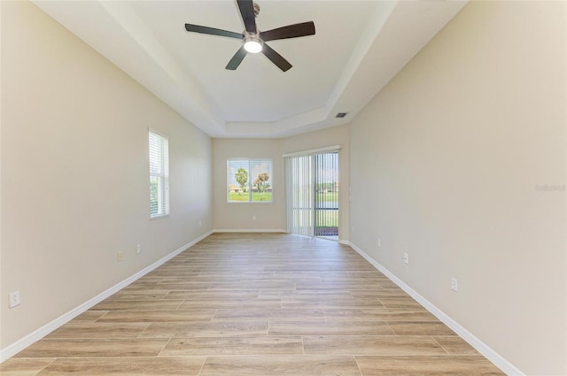 8772 Stone Harbour Loop, Bradenton, FL 34212 - spare room with a raised ceiling, a ceiling fan, and light wood-style flooring