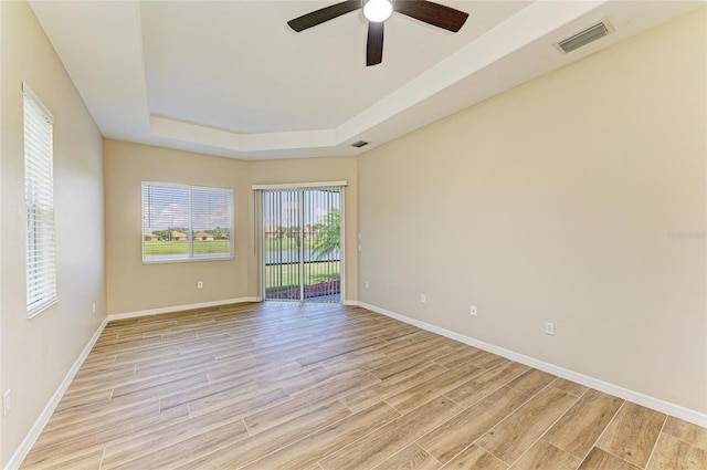 8772 Stone Harbour Loop, Bradenton, FL 34212 - empty room featuring light wood finished floors, a tray ceiling, and a ceiling fan