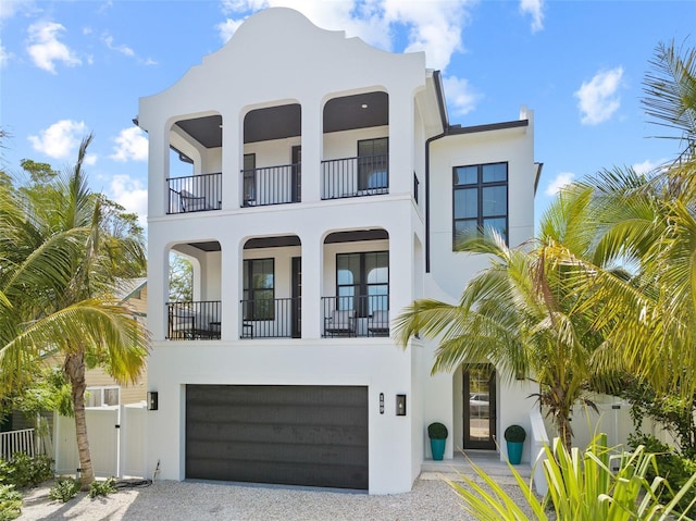 109 Palmetto Ave, Anna Maria, FL 34216 - view of front facade with stucco siding, a balcony, gravel driveway, a garage, and a gate