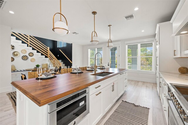 109 Palmetto Ave, Anna Maria, FL 34216 - kitchen with a sink, butcher block countertops, light wood-style flooring, healthy amount of natural light, and recessed lighting
