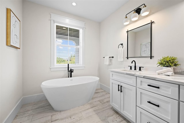 109 Palmetto Ave, Anna Maria, FL 34216 - bathroom with vanity, a freestanding bath, baseboards, recessed lighting, and wood finished floors