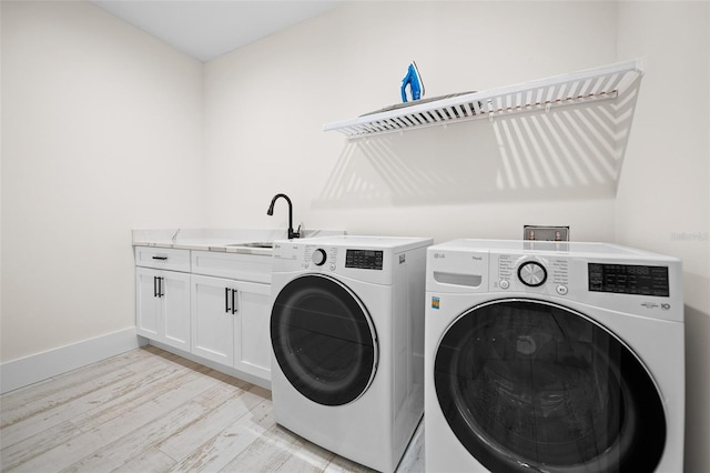 109 Palmetto Ave, Anna Maria, FL 34216 - washroom with light wood-style floors, washer and dryer, cabinet space, and baseboards