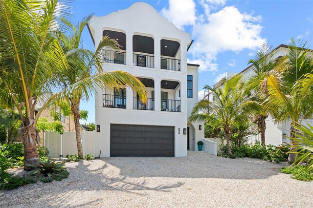 109 Palmetto Ave, Anna Maria, FL 34216 - view of front facade with a balcony, stucco siding, gravel driveway, and a garage