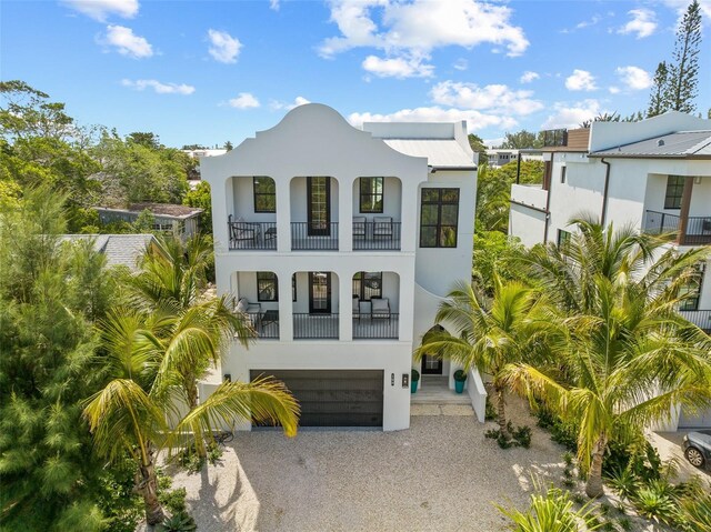 109 Palmetto Ave, Anna Maria, FL 34216 - view of front of home featuring a balcony, driveway, stucco siding, and an attached garage
