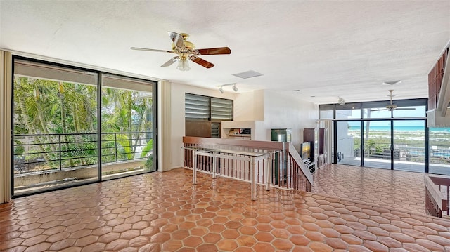 222 Beach Rd Unit 7, Sarasota, FL 34242 - empty room featuring ceiling fan, a wall of windows, and a textured ceiling