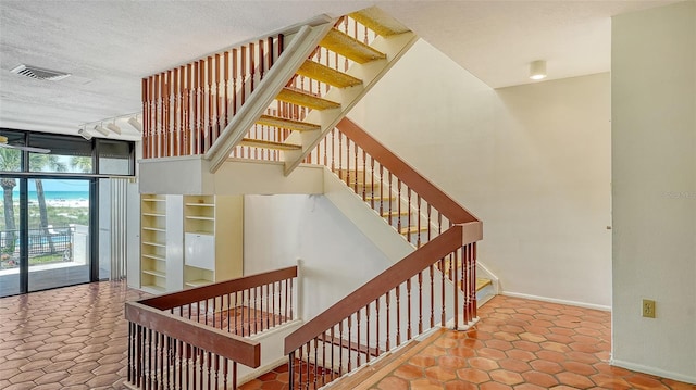 222 Beach Rd Unit 7, Sarasota, FL 34242 - staircase featuring a textured ceiling, expansive windows, and built in features