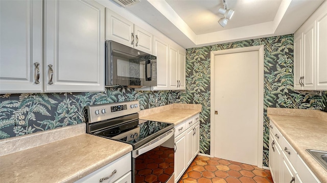 222 Beach Rd Unit 7, Sarasota, FL 34242 - kitchen with stainless steel electric stove, black microwave, wallpapered walls, a raised ceiling, and track lighting