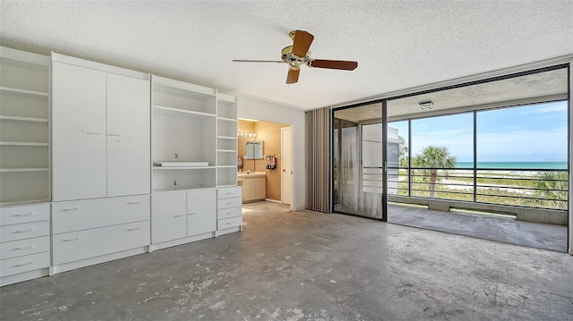 222 Beach Rd Unit 7, Sarasota, FL 34242 - unfurnished bedroom featuring access to outside, unfinished concrete floors, a textured ceiling, a water view, and a wall of windows
