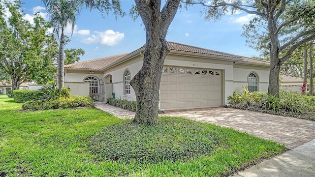 3317 Highlands Bridge Rd Unit 61, Sarasota, FL 34235 - view of home's exterior featuring stucco siding, a tile roof, an attached garage, and decorative driveway