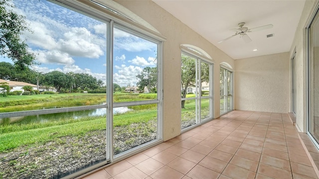 3317 Highlands Bridge Rd Unit 61, Sarasota, FL 34235 - unfurnished sunroom with a textured wall, a water view, healthy amount of natural light, and tile patterned flooring