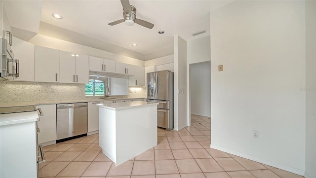 3317 Highlands Bridge Rd Unit 61, Sarasota, FL 34235 - kitchen featuring appliances with stainless steel finishes, a ceiling fan, light countertops, decorative backsplash, and a center island