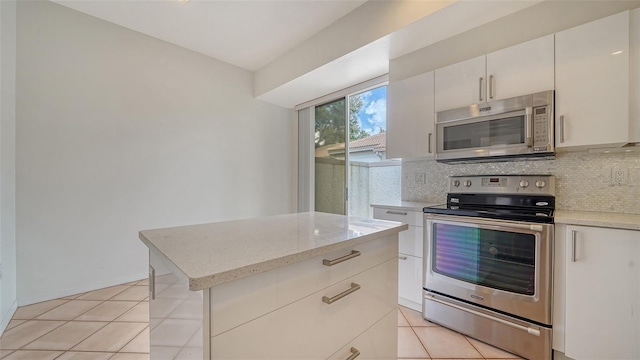 3317 Highlands Bridge Rd Unit 61, Sarasota, FL 34235 - kitchen featuring appliances with stainless steel finishes, tasteful backsplash, light stone countertops, and light tile patterned flooring