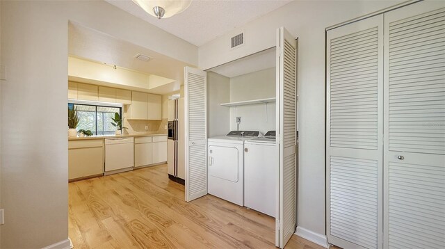 137 Woodland Pl, Osprey, FL 34229 - laundry room with washer and dryer and light wood-style floors