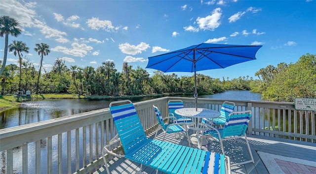 137 Woodland Pl, Osprey, FL 34229 - deck with outdoor dining space, a water view, and view of scattered trees