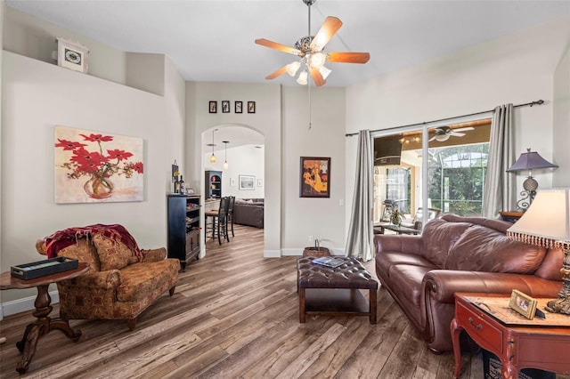743 Stonecrest Dr, Sarasota, FL 34232 - living room with ceiling fan, arched walkways, wood finished floors, baseboards, and a high ceiling